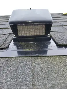Rooftop dryer vent cap installed on shingle roof for proper exhaust airflow and lint removal
