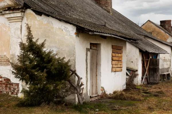 Old deteriorating home with aged exterior walls and roof