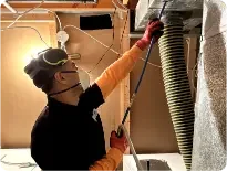 Technecian performing air duct cleaning spokane